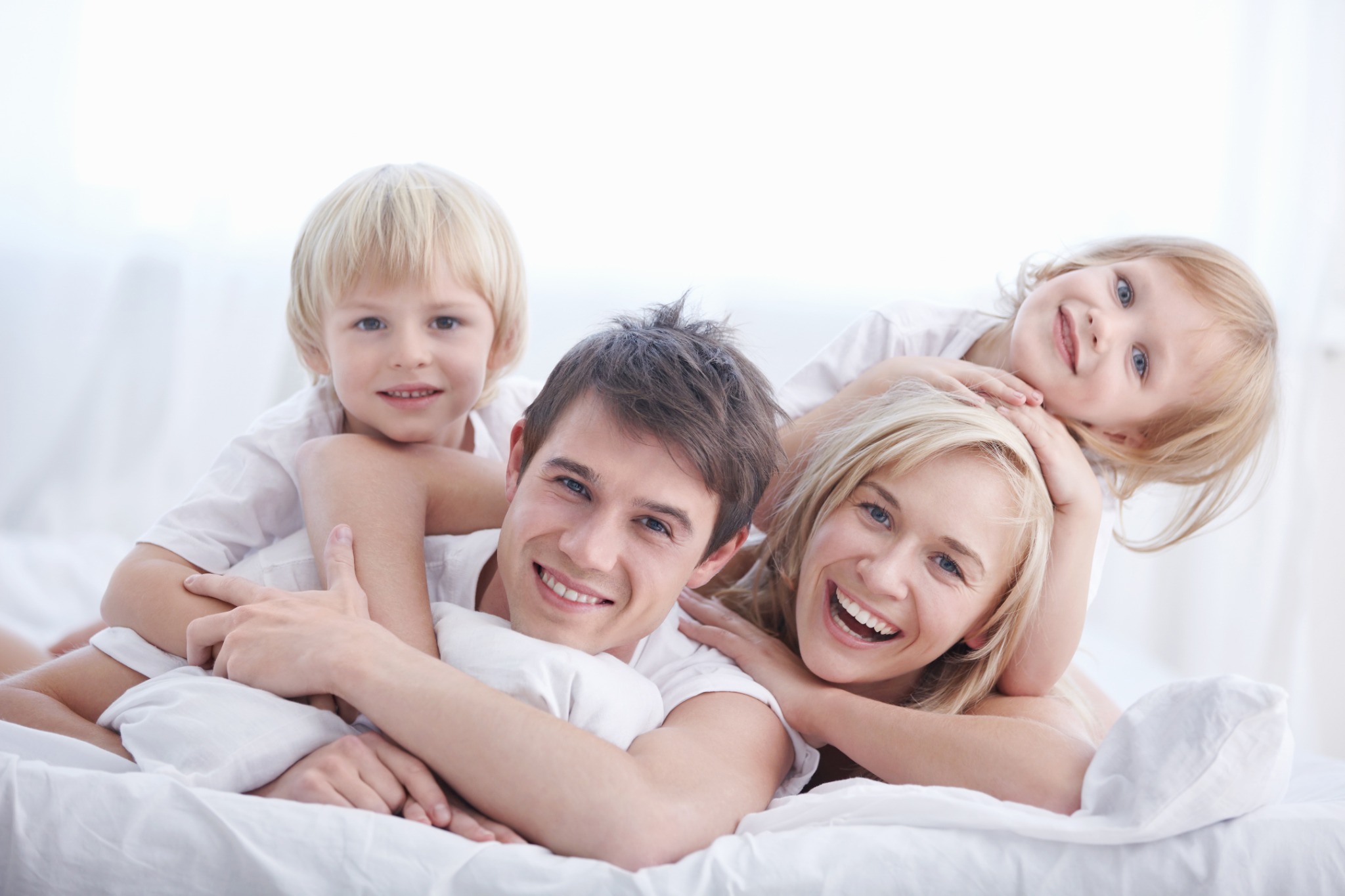 Happy family relaxing in bed after professional bed bug service
