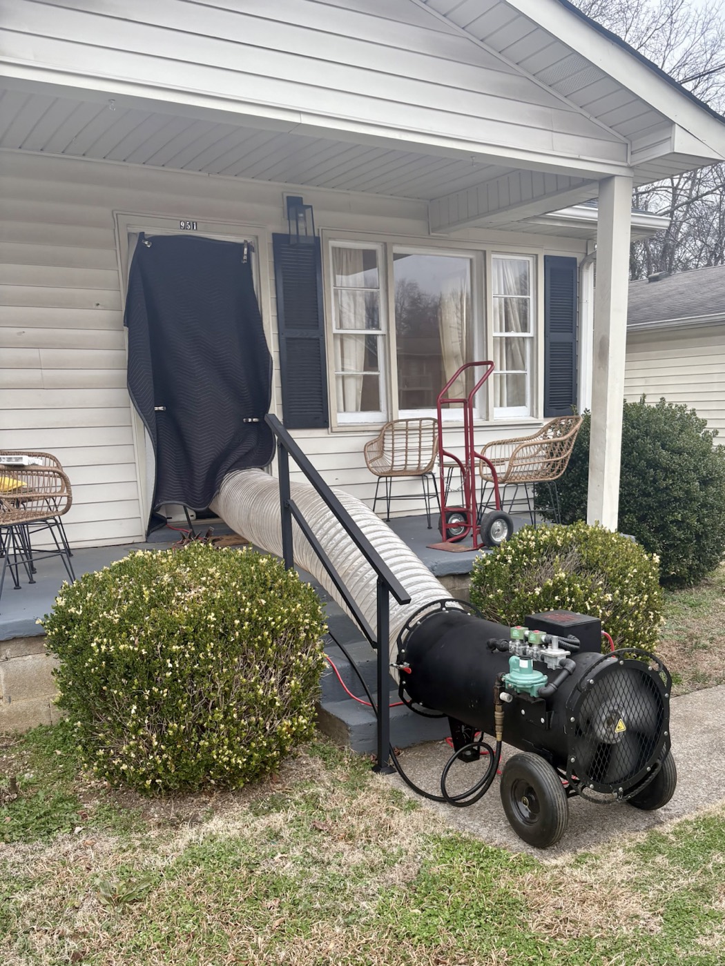 EcoForce treatment hose running through the front porch entry of a white house